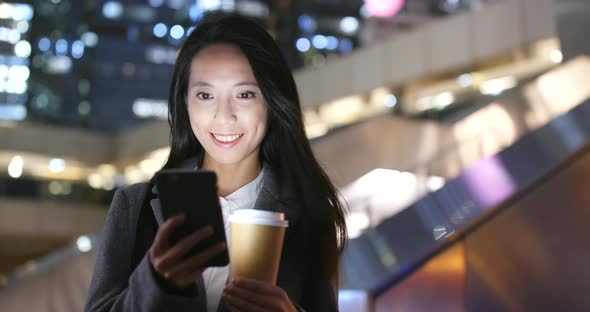 Business woman use of mobile phone in city at night