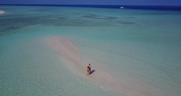 Romantic people on honeymoon vacation live the dream on beach on sunny white sandy background 