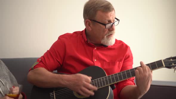 Elderly Couple Husband and Wife Singing at Home While Sitting on the Couch