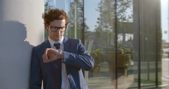 Young Businessman in Formal Wear Looking at Wristwatch While Waiting Outside