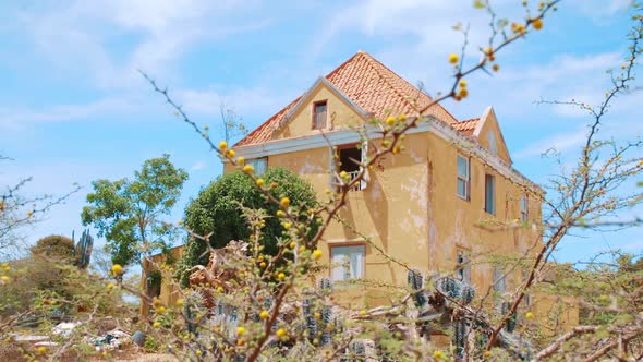 Abandoned house with chipped yellow paint in the Curacao, Caribbean desert, PAN LEFT