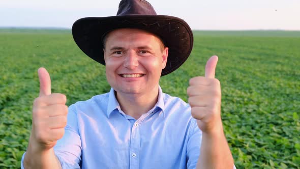 Portrait of a Young Farmer in a Blue Shirt Raising His Thumbs Up