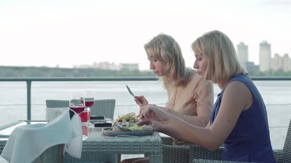 Side View of Wealthy Caucasian Women Dining in Outdoor Restaurant. Portrait of Confident Adult