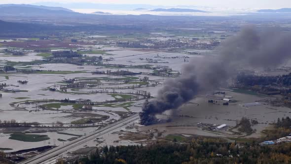 Aerial View Of Catastrophic Flooding And Black Smoke Rising From Burning RV Vehicles In Abbotsford,