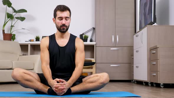 Young Fit Man Doing Yoga, the Lotus Pose, on the Floor of His Flat