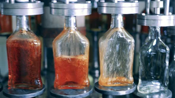 Cognac Is Getting Poured Into Empty Glass Bottles