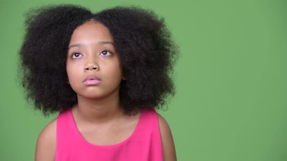 Young Cute African Girl with Afro Hair Looking Bored