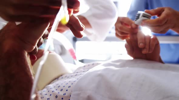 Doctor placing electronic pulse clip on patients finger