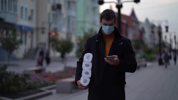 Men Walking in Medical Mask with Toilet Paper and Smartphone During the Second Wave Quarantine