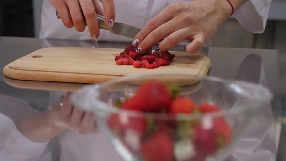 Close-up of Woman Hands Cutting Strawberries on Cutting Board.