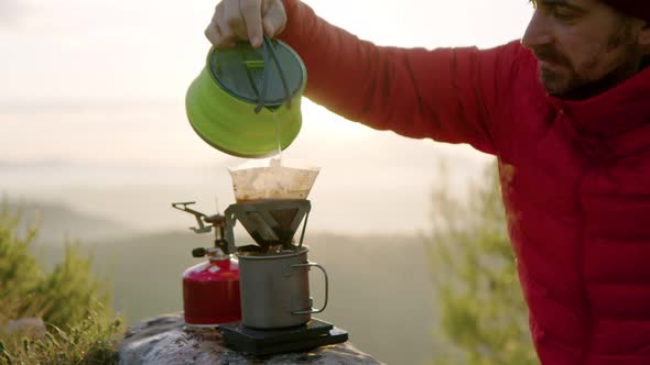 Man Traveller Makes Coffee in Camping Gear