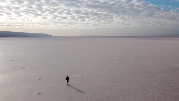 Beautiful girl walking on the pink salt lake, the largest dry lake in Turkey and one of the largest