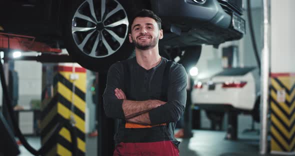 In a Modern Auto Service Attractive Mechanic Guy