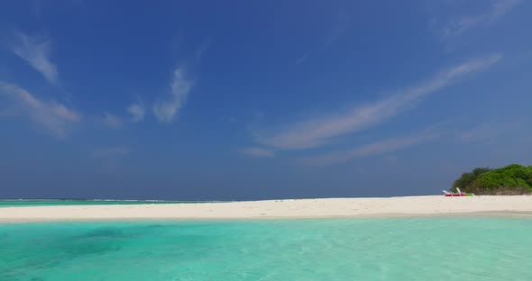 Wide angle aerial travel shot of a sunshine white sandy paradise beach and blue ocean background in 