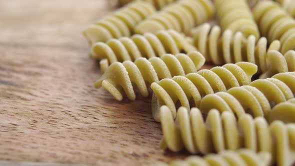 Green vegetable raw italian fusilli pea pasta on a wooden background. Macro