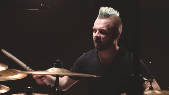 Drummer performing in a studio setting.