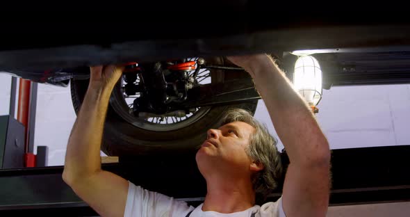 Male mechanic servicing a car 