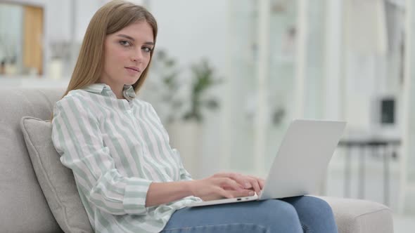 Thumbs Up By Young Young Woman Working at Home