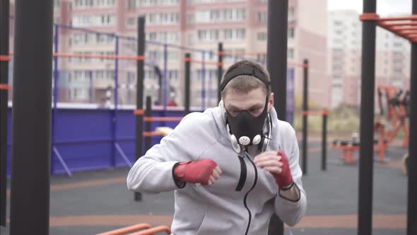 Man in a Training Mask on His Face Boxing on a Sports Street Playgroundslow Mo