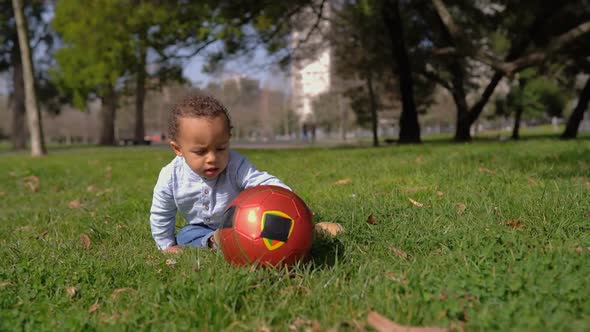 Boy Playing with Ball, Trying To Rise It Up, Biting It