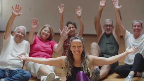 Female Teacher Sitting on Floor with Dance Group of Retirees