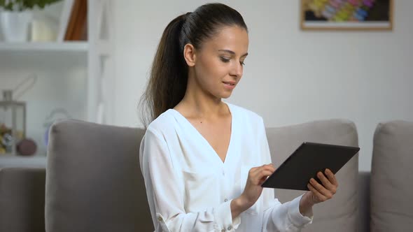 Young Woman Using Tablet PC at Home, Looking at Camera, Social Network, Online