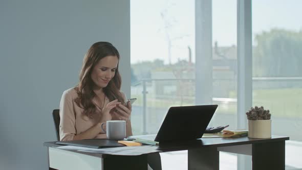 Business Woman Scrolling Mobile at Work Place. Smiling Lady Having Break