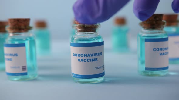 Closeup of Gloved Hand Takes Vial Coronavirus Vaccine