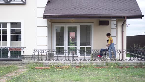 Extreme Wide Shot Cheerful African American Man Rolling Wheelchair As Teenager Girl Riding Kick