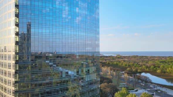 Rising aerial of skyscraper, water and green landscape in Buenos Aires