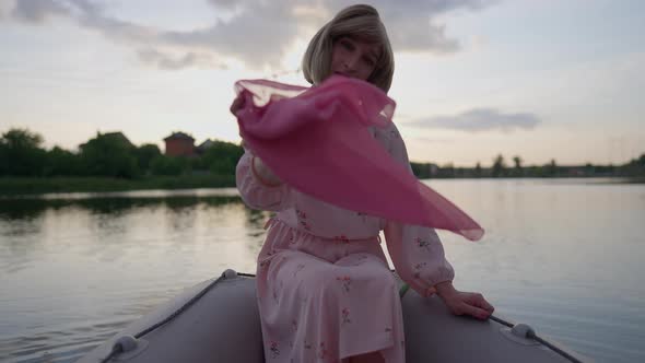 Portrait of Smiling Confident Nonbinary Trans Woman in Dress Looking at Camera Shaking Pink Kerchief