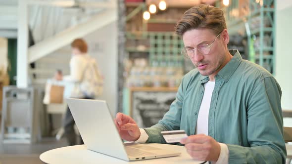 Online Payment Failure on Laptop By Middle Aged Man in Cafe