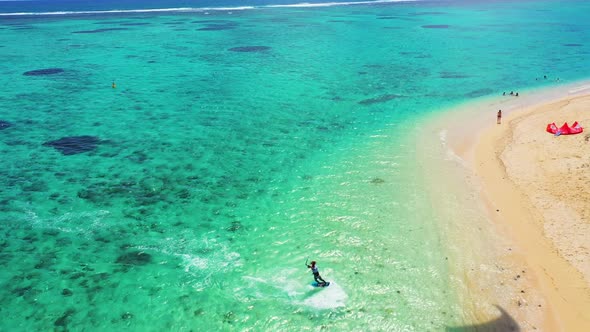Kitesurfing Le Morne, Mauritius. Drone view flying backwards in front of kite surfer. Kite surfer su
