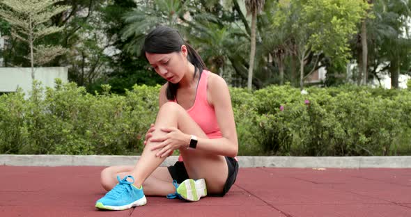 Sport woman getting hurt on legs at outdoor park