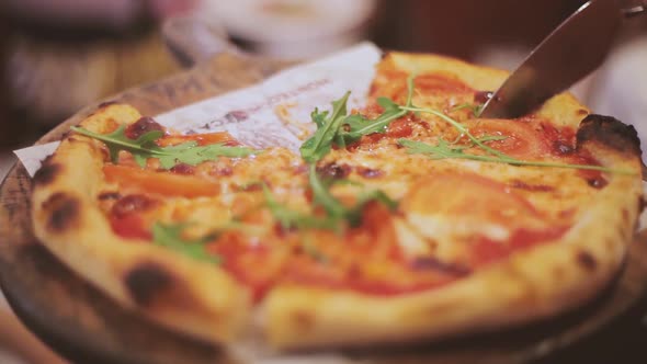 Woman waiter serving hot pizza to restaurant guests