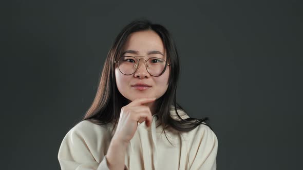 Portrait of Asian Thinking Pondering Girl Having Idea Moment Pointing Finger Up