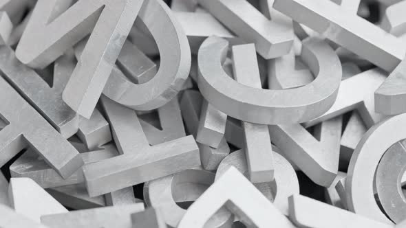 Full Frame Closeup Looped Slowly Rotating Background of Silver Metal Letters with Selective Focus