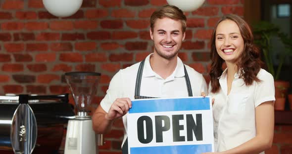 Waiter and Customer Holding a Board with Open Sign