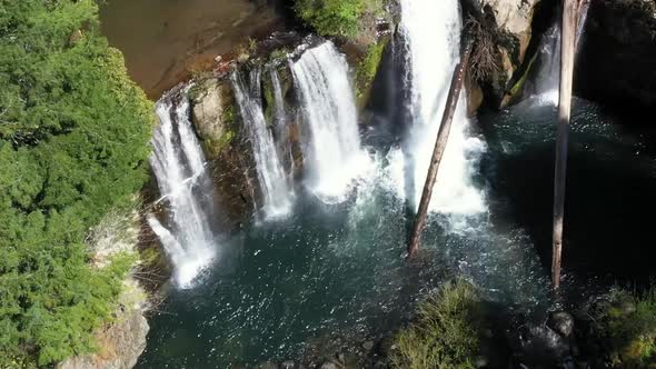 Drone footage, still, looking down at multiple water falls flowing at Coquille falls. Pristine clean