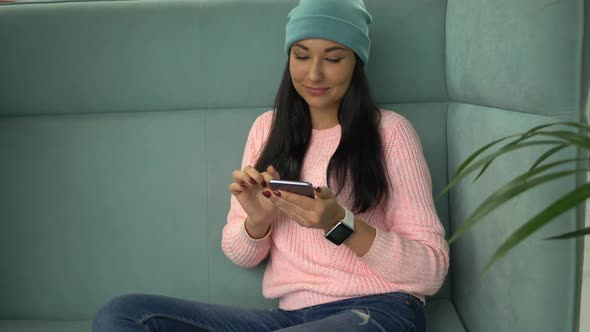 Millenial Mixed Race Hipster Woman in Cafe Chatting with Friends Using Cellphone
