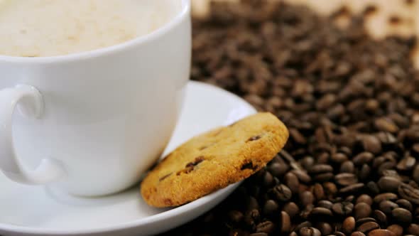 Coffee with cookie on roasted beans