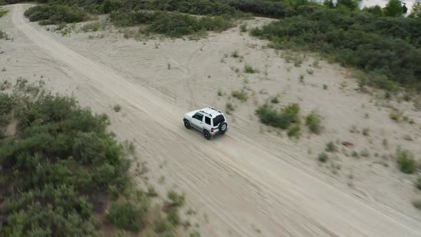 Aerial View of a Car Driving on Sand