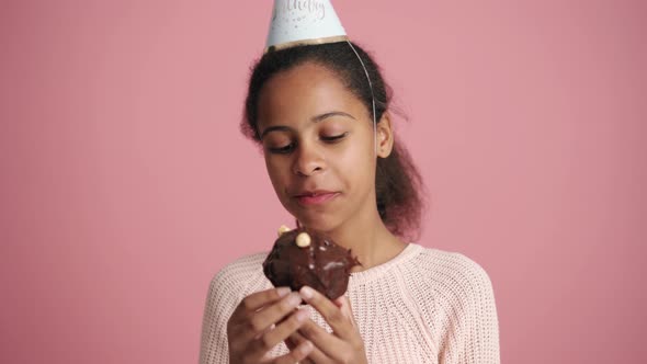 Handsome African little girl eating holiday cupcake