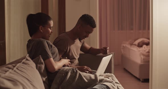 Man and Woman Shopping Online on Sofa