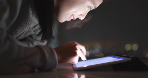 Woman use of tablet computer at night