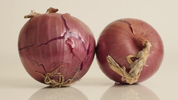 Pair of  onions with red skin and white flesh close-up 4K 2160p 30fps UltraHD tilting footage - Orga