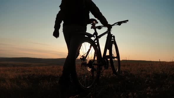 Silhouette Cyclist Man on a Mountain at Sunset.