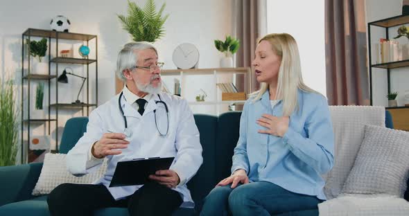 Doctor Listening Upset Blond Woman which Telling Health Complaints During His Home Visit