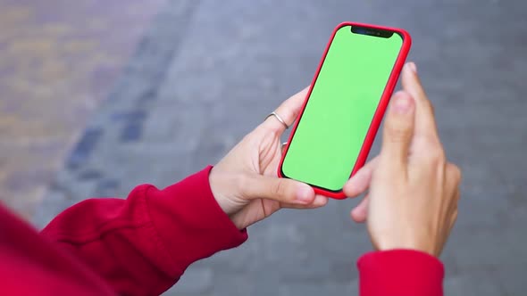 Girl Holding Red Smartphone Wearing Red Shirt and Swiping Chromakey Green Screen