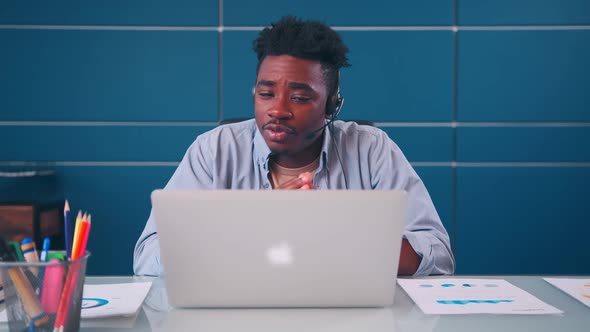 African American Man Executive Wears Headset Video Calling on Laptop